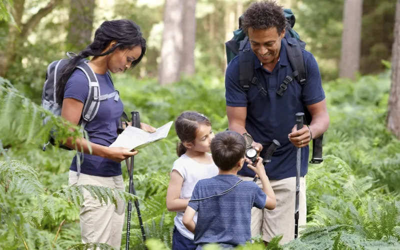 Family hiking and looking at compass