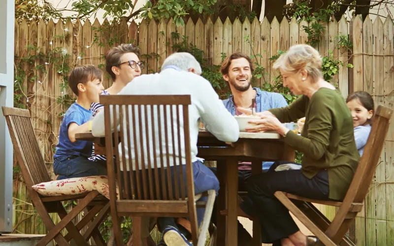 Retired couple and kids eating dinner outside