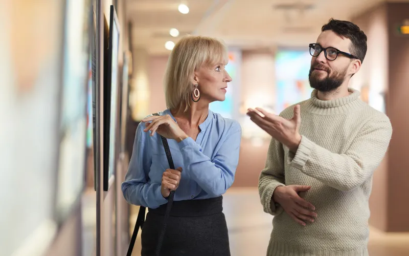 Couple discussing a painting in art gallery