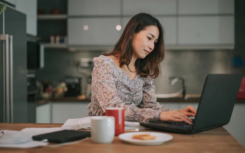 Woman using laptop in kitchen