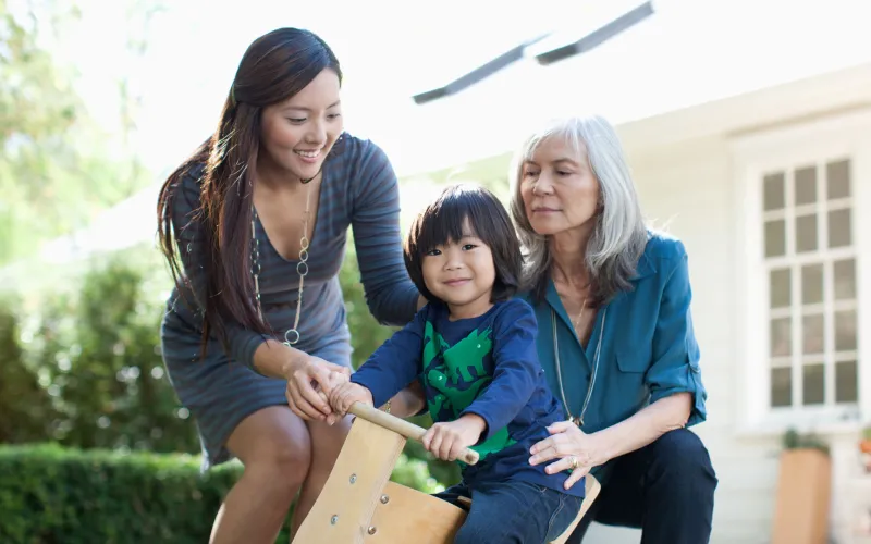 Grandmother, daughter and grandson outside home