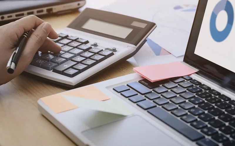 Person using calculator and laptop