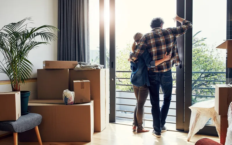 Couple looking out window after moving in