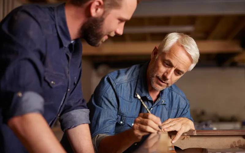 A Father and son working at their carpentry business. 