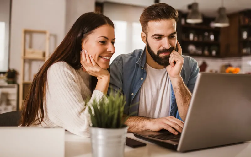 A couple working on their finances on their laptop together. 