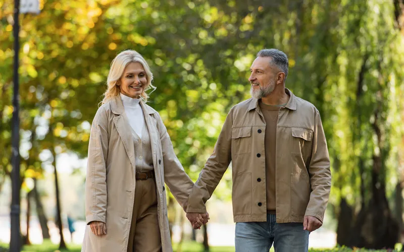 A couple holding hands walking in a park