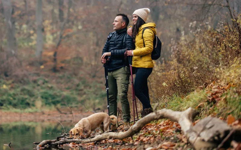 A man and woman in the woods together in the Autumn.