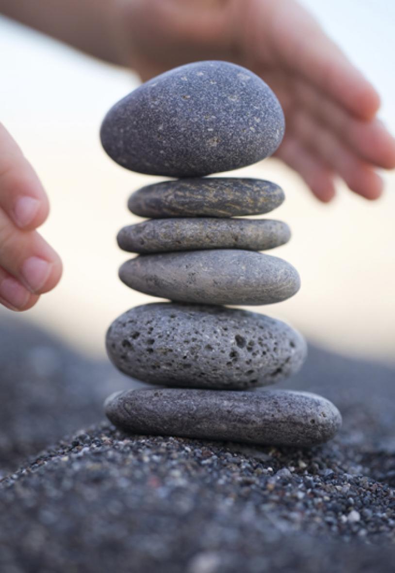 Person stacking small rocks