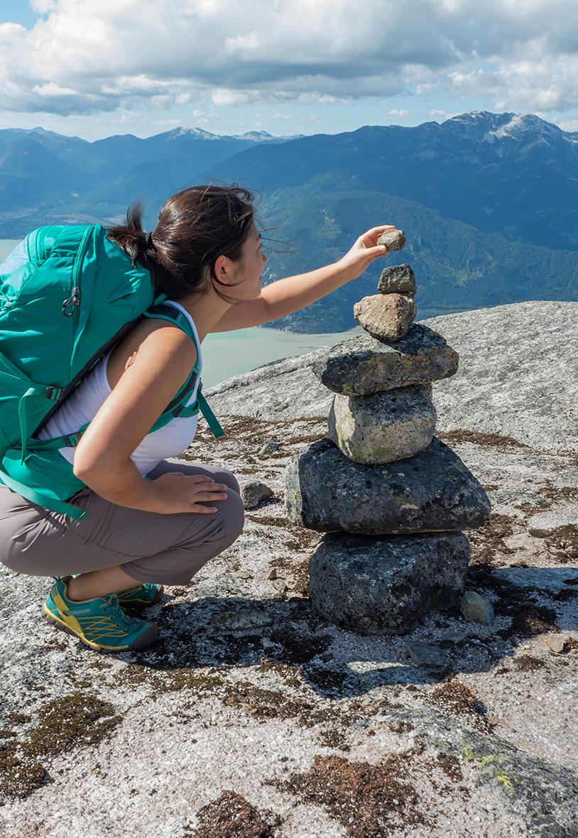 Woman building inukshuk out of small stones