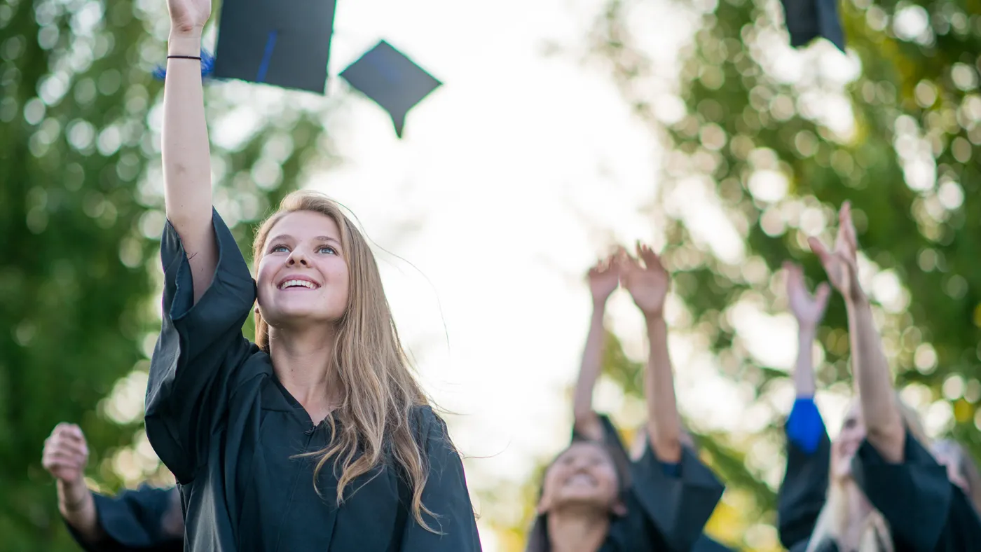 Lady throwing graduation hat in the air