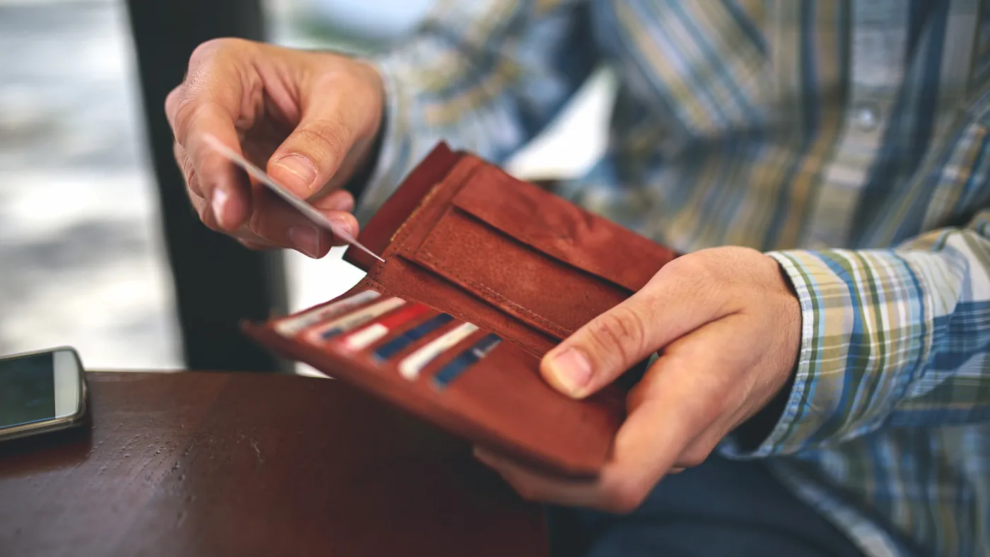 Man taking credit card out of his wallet