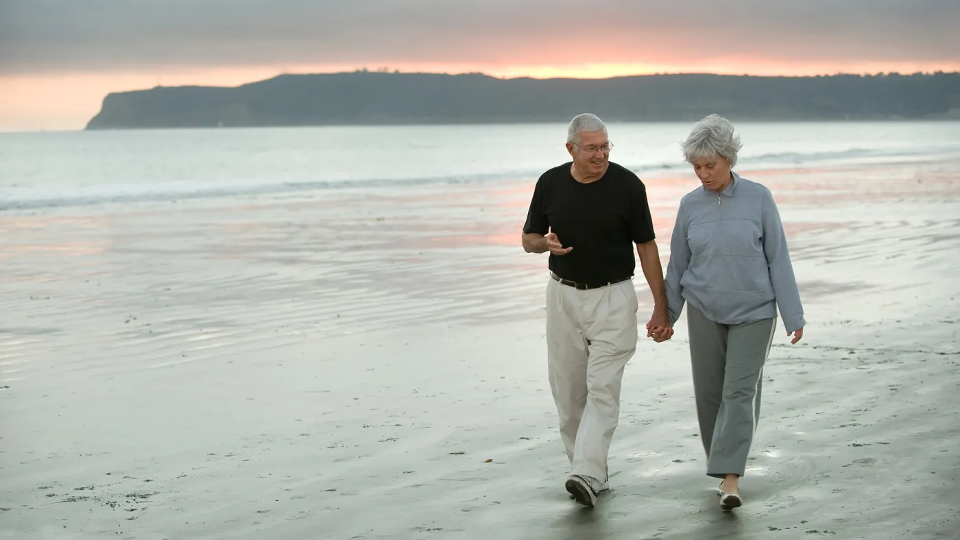 Older couple walking on beach
