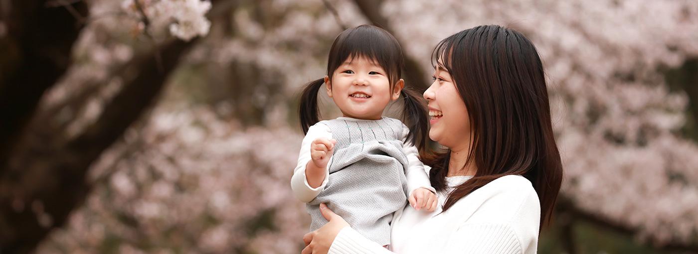 Mother and daughter looking at cherry blossom trees