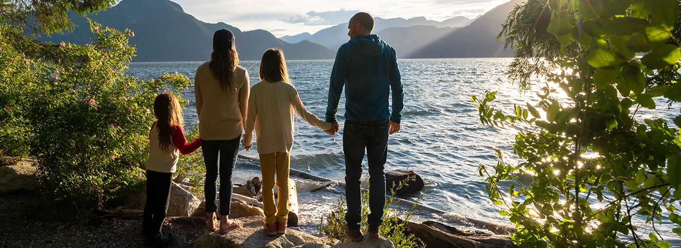 Family at lake shore at sunset