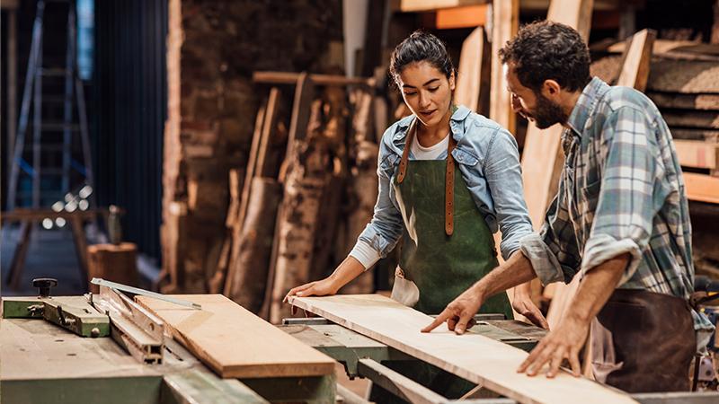Man and woman working in a carpentry workshop.