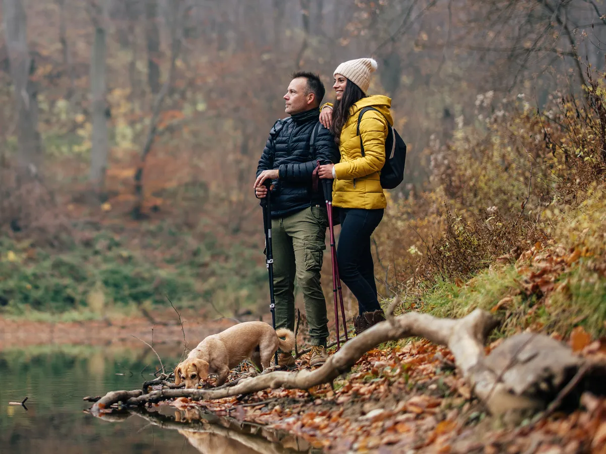 A man and woman in the woods together in the Autumn.