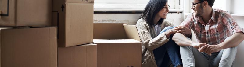 Couple sitting in new home with boxes