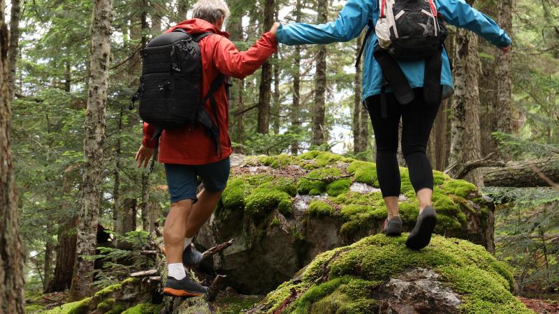 Couple holding hands hiking over rough terrain