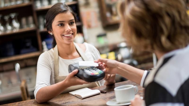 Woman paying for coffee with debit