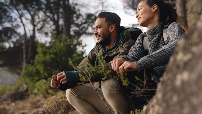 Couple sitting in forest looking at view