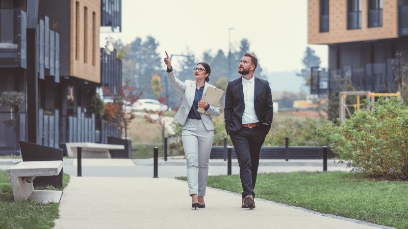 Couple walking in front of townhomes