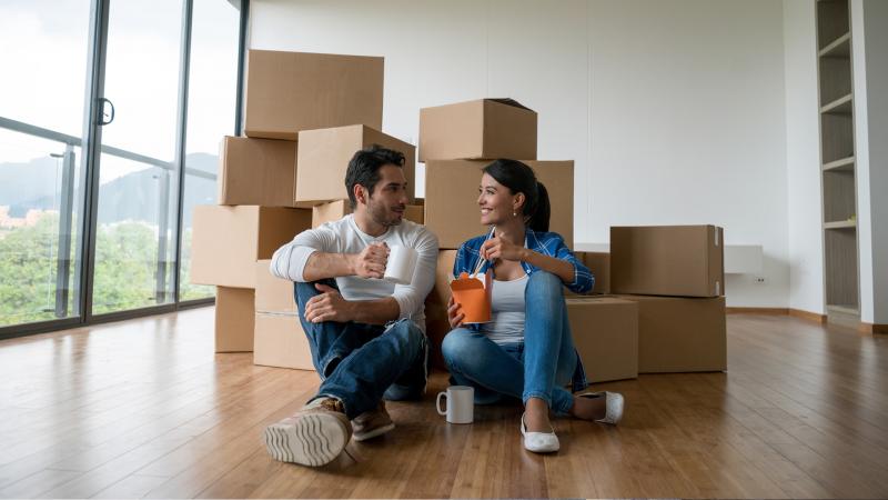 Couple relaxing after unpacking boxes in their new home