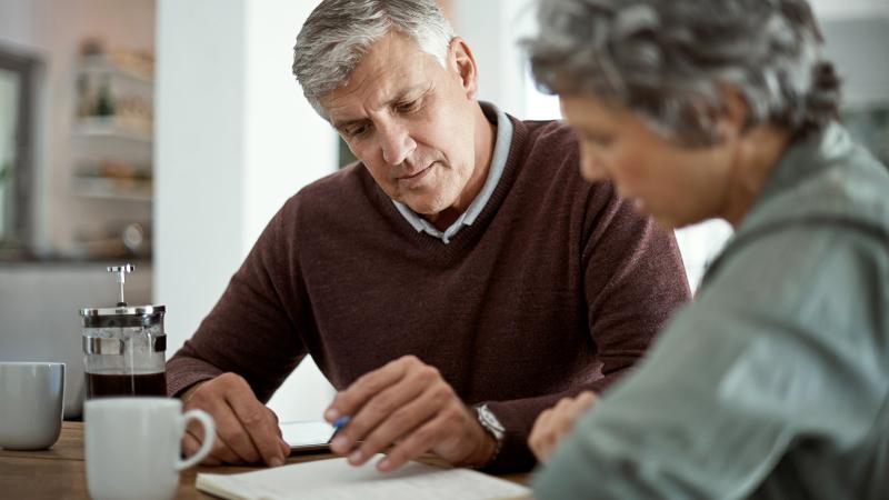 Older couple planning at kitchen table