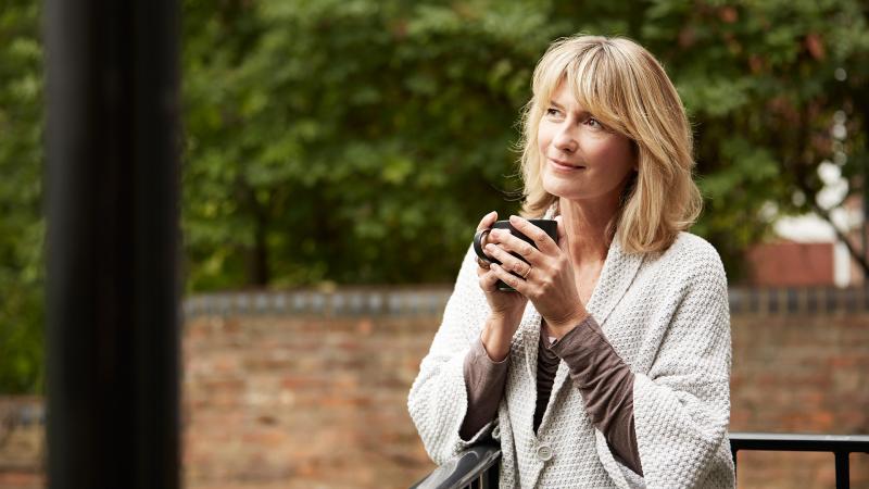 Woman sipping morning coffee outside