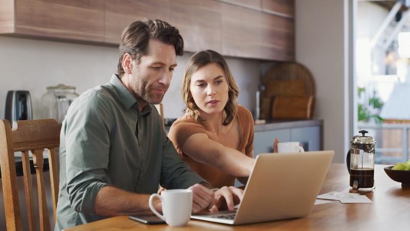 Couple in home doing research on laptop