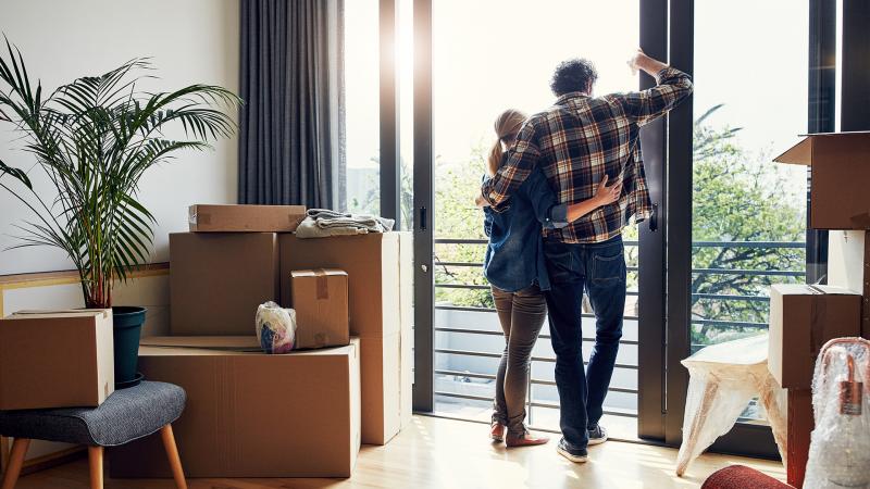 Couple looking out window after moving in